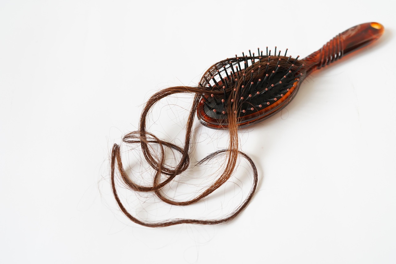 Immagine di ciocche di capelli caduti su un pettine, simbolo della perdita dei capelli.